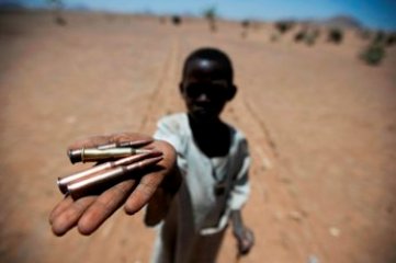 A child collects bullets from the ground in Rounyn, a village located about 15 km north of Shangil Tobaya, North Darfur on 27 March 2011 (Albert Gonzalez Farran / UNAMID)