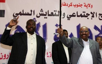 Sudan's President Omer Hassan al-Bashir waves with Governor of South Kordofan Ahmed Haroun (L), to participants of Civil Administrative Conference during his first visit to Kadugli, capital of South Kordofan state, August 23, 2011 (Reuters)