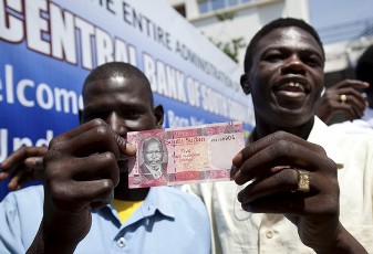 Men from South Sudan display new currency notes outside the Central Bank of South Sudan in Juba July 18, 2011 (Reuters)