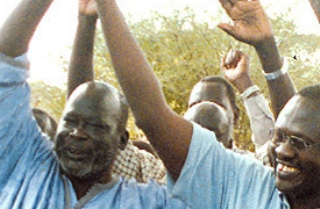 John Garang (left) the late SPLM leader reconciles with Riek Machar (Right) in 2002. (New Sudan Foundation)