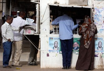 Sudanese buy newspapers to follow the news of Sudan's first multiparty elections in decades in Khartoum, Sudan. (AP, Amr Nabil)
