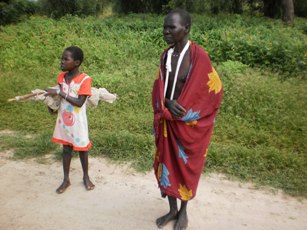 Nyatiek Yiey Weal escaping with her young daughter after being shot by cattle rustlers in Thor, Mayiandit County, South Sudan. Sept. 11, 2011 (ST)