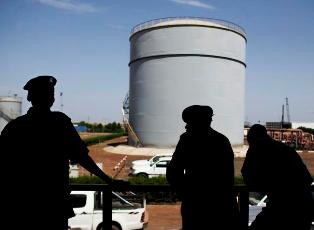 In this Wednesday Nov. 17 2010 photo, Southern Sudanese security forces wait outside the control room of the Petrodar oil facility in Paloich, southern Sudan (AP)