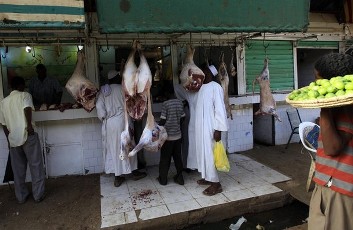 Men wait to buy meat at the market in Khartoum, Sudan (Reuters)