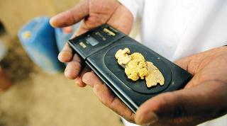 A Sudanese merchant weighs gold in al-Shirik, Sudan (AFP)