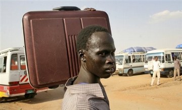 A southern Sudanese man carries his suitcase as he makes his way to a bus headed to southern Sudan, at a staging area 20 miles south of Khartoum, Sudan, Thursday, Oct. 28, 2010  (AP Photo/Abd Raouf)