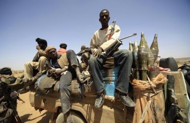 Rebel forces sit on a vehicle as they guard during the visit of JSR Ibrahim Gambari to Fanga Suk village, in East Jebel Marra (West Darfur), on March 18, 2011 (Reuters)