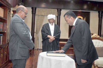 Sudan's newly appointed Presidential Assitant Jaffar Mohamed Osman al-Mirghani (R) takes his oath of office in front of Sudan's President Omer Hassan al-Bashir in Khartoum November 30, 2011