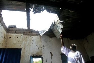 A Sudanese man points to damages at his house caused by fighting between government forces and SPLM-N rebels with strong ties to South Sudan, in Kadugli, South Kordofan on October 21 (AFP)