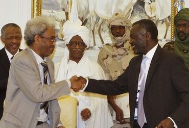 Amin Hassan Omer shakes hands with Gibril Ibrahim in Doha 17 Feb 2009 after exchanges agreements of good intentions with the rebel Justice and Equality Movement (file/Reuters)