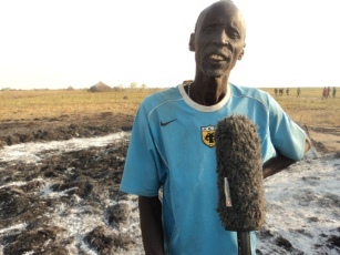 Chief Philip Bol speaking to press in front of the remains of a Luak (Dinka Bor traditional building), Akot, Jonglei, South Sudan, December 6, 2011 (ST)