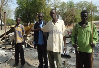 Businessman, Gatluak Anyang, and his brothers next to the remains of his shop, Padiet, Duk, Jonglei, South Sudan, January 18, 2012 (ST)