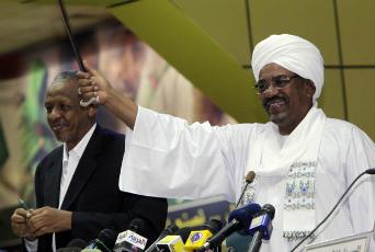 Sudan's President Omar Hassan al-Bashir (R) waves to participants while the president's advisor Nafi Ali Nafi watches during the National Congress Party's third general conference in Khartoum on Nov. 24, 2011.  Mohamed Nureldin Abdallah/Reuters
