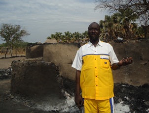 Commissioner of Duk county, January 18, 2012 (ST) Mochnom Wuor showing the remains burnt houses, Padiet, Duk, Jonglei, South Sudan,