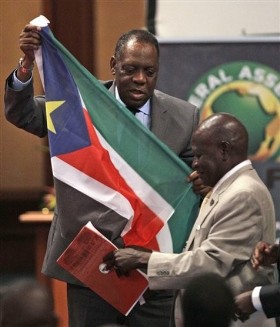 Confederation of African Football (CAF) president Issa Hayatou, left, receives South Sudan's national flag from its federation president Oliver Benjamin, right, during the CAF General Assembly in Libreville, Gabon, Friday Feb. 10, 2012. (AP)