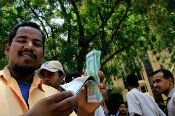 A Sudanese man shows off the new currency in front of Central Bank of Sudan, in the capital Khartoum on August 27, 2011 (AFP)