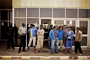 Employees of the PETRODAR Operating Company, a Chinese-Malaysian oil consortium operating in South Sudan, await the arrival of ranking government officials at the Paloich airport in Melut County, South Sudan on Tuesday Feb. 21, 2012 (AP)