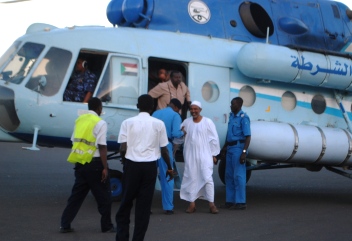 Sudan’s minister of agriculture and forestry Abdel Halim al-Mutafi (dressed in traditional Jalabiah) is welcomed by Sudanese police personnel at his arrival in Khartoum on Monday 27 Feb 2012 (ST)