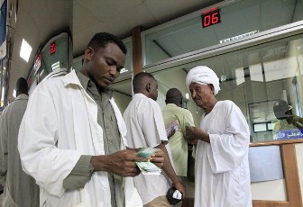 People count their money after receiving the new Sudanese currency at a branch of the Central Bank of Sudan in Khartoum July 24, 2011 (Reuters)