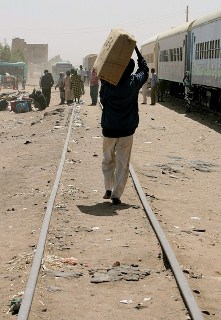 A South Sudanese man carrying his belongings onto a train organised by IOM at Khartoum, March 1, 2012 (Getty)