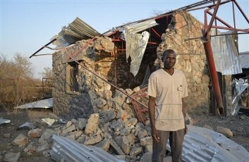 In this photo taken Wednesday, Feb. 1, 2012, school Pastor Zachariah Boulus stands next to a building in the compound of the Heiban Bible College, following a bombing on Wednesday, at the school which was built by Samaritan's Purse, a North Carolina-based aid group, in Heiban, Southern Kordofan, Sudan (AP)