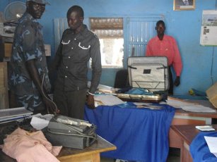 Two South Sudanese policemen showing the remains of the broken bags and boxes in their office in Bor. 14 March 2012 (ST)