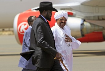 Sudan’s President Omar al-Bashir (R) welcomes his South Sudanese counterpart Salva Kiir (C) during his arrival at Khartoum Airport October 8 ,2011 (REUTERS)
