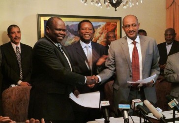 Pagan Amum (L), chief negotiator from South Sudan, Piere Buyoya (C), lead mediator for the African Union and Sudan’s head negotiator Idriss Abdel Qadir, shake hands at the end of African Union-led talks between Sudan and South Sudan in Addis Ababa on March 13, 2012. (Getty)