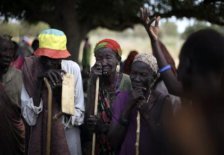 South Sudanese who fled the recent ethnic violence listen as a woman describes the attacks, in Gumuruk, Jonglei, January 12, 2012 (Reuters)