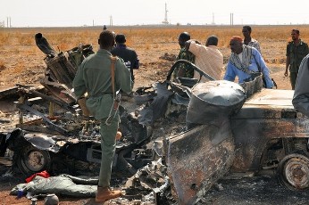 Sudanese troops and onlookers stand next to a burnt out military vehicle in Sudan's southern oil centre of Heglig (GETTY)