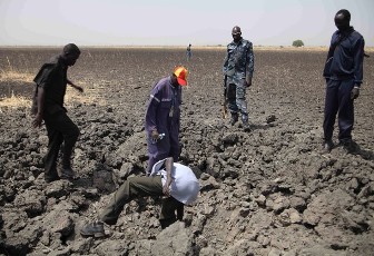 South Sudanese men look at shrapnels from one of the bombs which hit El Nar oil field on March 1, in Unity State on March 3, 2012 (AFP)
