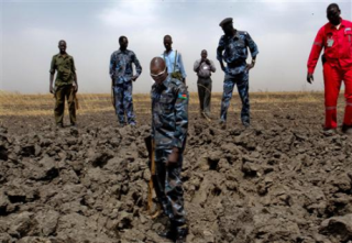 A South Sudanese policeman stands in a bomb crater in the El Nar oil field, Unity State, where rebels claimed responsibility for an attack, March 3, 2012 (REUTERS)