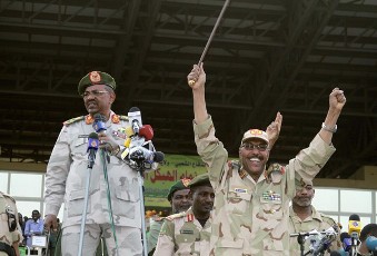 Sudanese President Omar Hassan al-Bashir (L) greets the crowd with Defense Minister Abdel Raheem Muhammad Hussein (R) during a Popular Defense Force rally in Khartoum March 3, 2012 (Reuters)
