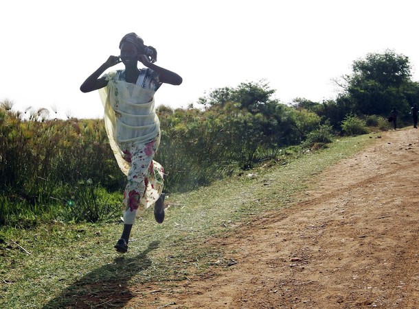 A woman runs along a road during an air strike by the Sudanese air force in Rubkona near Bentiu April 23, 2012 (Reuters/Goran Tomasevic)