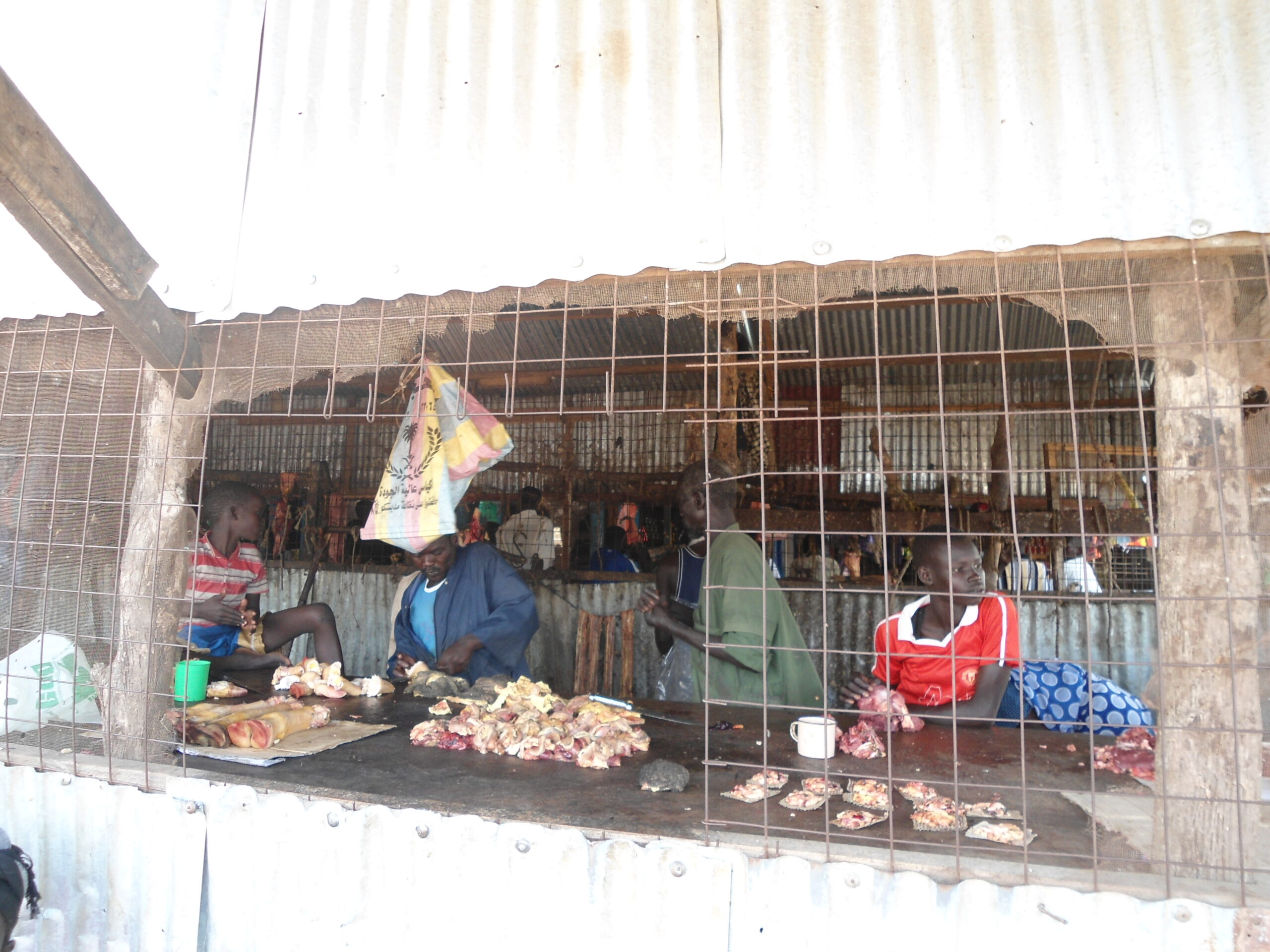 Butcher cutting a piece of meat while waiting for customers in Bor Marol Market, 27 April 2012 (ST)