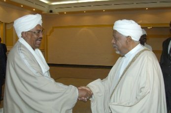 FILE PHOTO - Sudan's president Omer Al-Bashir (L) shakes hands with DUP leader Mohamed Osman al-Mirghani