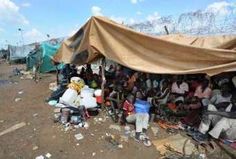 Sudanese refugees gather in a makeshift shelter after being displaced by conflict in Southern Kordofan earlier this year. (UN Photo_Paul Banks)
