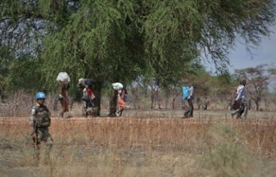 A UN peacekeeper escorts civilians who flee Abyei after its seizure by the Sudanese army in May 2011 (photo UN)