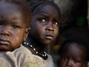 Girls sit in front of their shelter in Bram village in the Nuba Mountains in South Kordofan April 28, 2012 (Reuters)