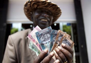 A man from South Sudan displays new currency notes outside the Central Bank of South Sudan in Juba July 18, 2011. (Reuters)