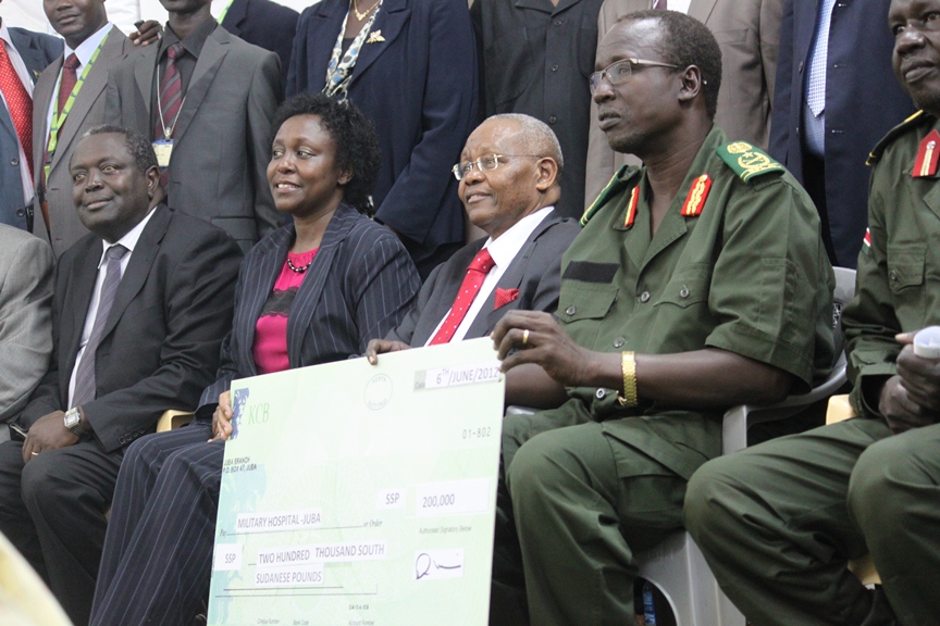 SPLA Gen. Pieng Deng Majok (R) holding a cheque with Kenya Central Bank (KCB) staff at the ceremony in Juba, Central Equatoria State, South Sudan 6 June 2012 (Julius N. Uma/ST)