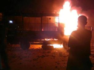A Sudanese protestor watches police truck burning after being set on fire by demonstrators in Al-Daim area in Khartoum on Friday (activist photos)