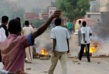 A group of protesters burns tyres to lock a street  in Khartoum (photo Al-Jazeera)