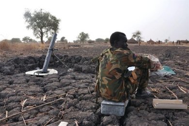 A soldier waits next to a foxhole in Panakuach, South Sudan on 27 April 2012 (AFP)
