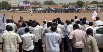 In this image grabbed from an AFP Video, Sudanese protesters gather as riot policemen stand guard during a demonstration in the capital Khartoum on July 13 (GETTY)