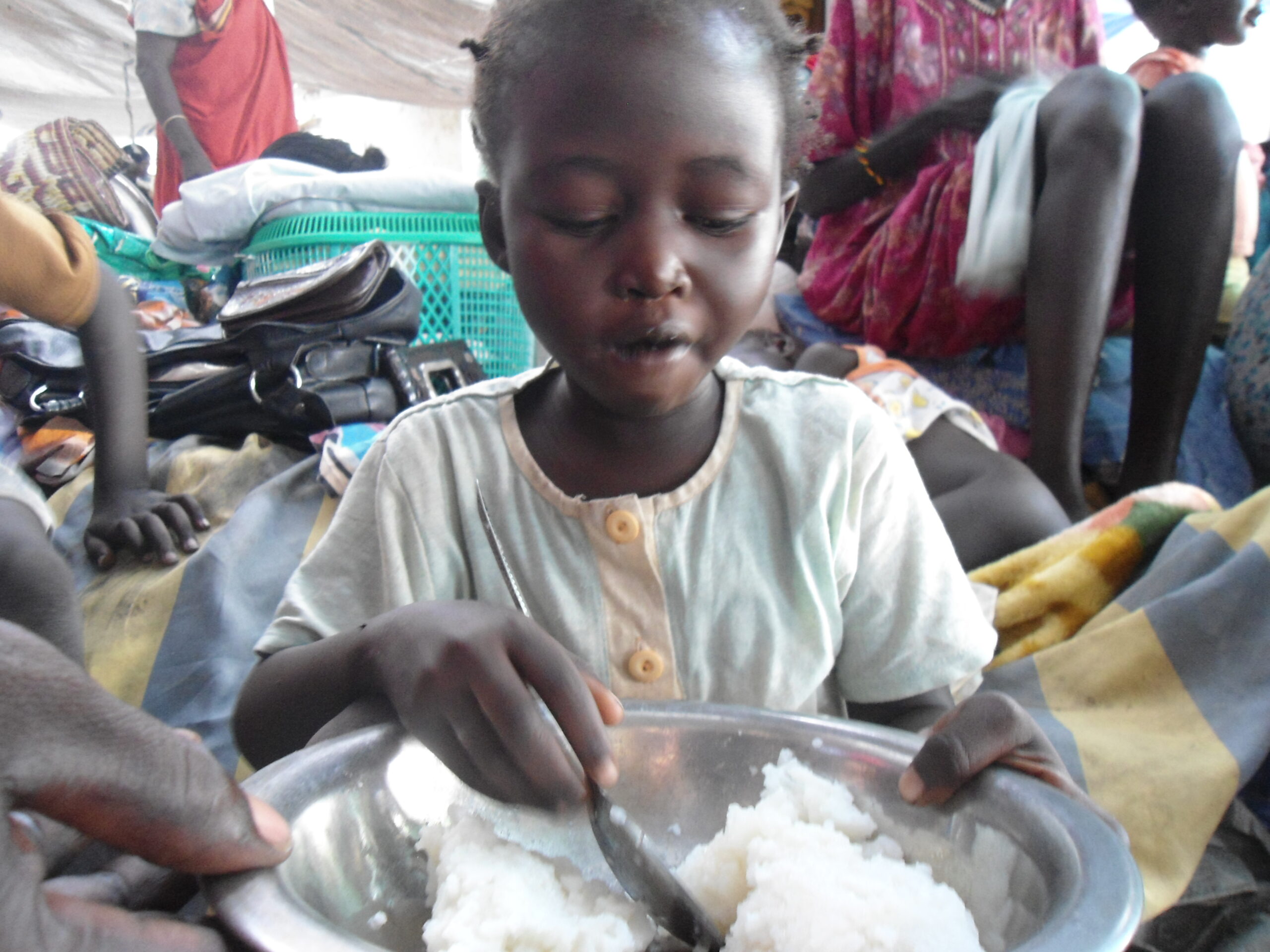 A returnee child eating boiled rice at Bor docking point, Jonglei, August 22, 2012 (ST)