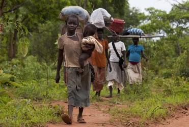 Sudanese refugees walk along the border road after crossing from North Sudan carrying their possessions July 2, 2012 in Jaw, South Sudan (Getty)