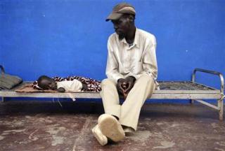 A father tends to his son in a looted hospital, Abyei, 2009 (Reuters)