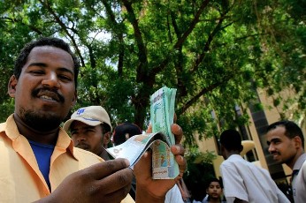 FILE PHOTO - A Sudanese man shows off the new currency in front of Central Bank of Sudan, in the capital Khartoum on August 27, 2011 (GETTY)