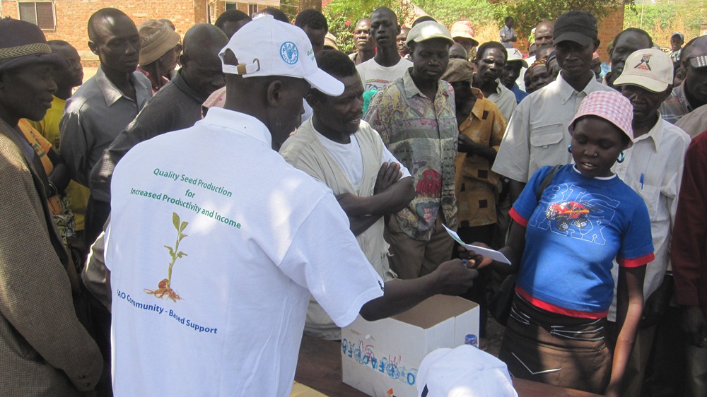 A UN FAO staff issues seed vouchers to farmers in Morobo County, Central Equatoria State, South Sudan, March 25, 2012 (ST)